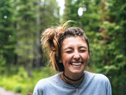 woman smiling near tree outdoor during daytime