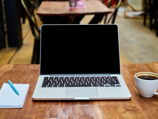 Persoon die werkt op een laptop in een café verbonden met openbaar wifi