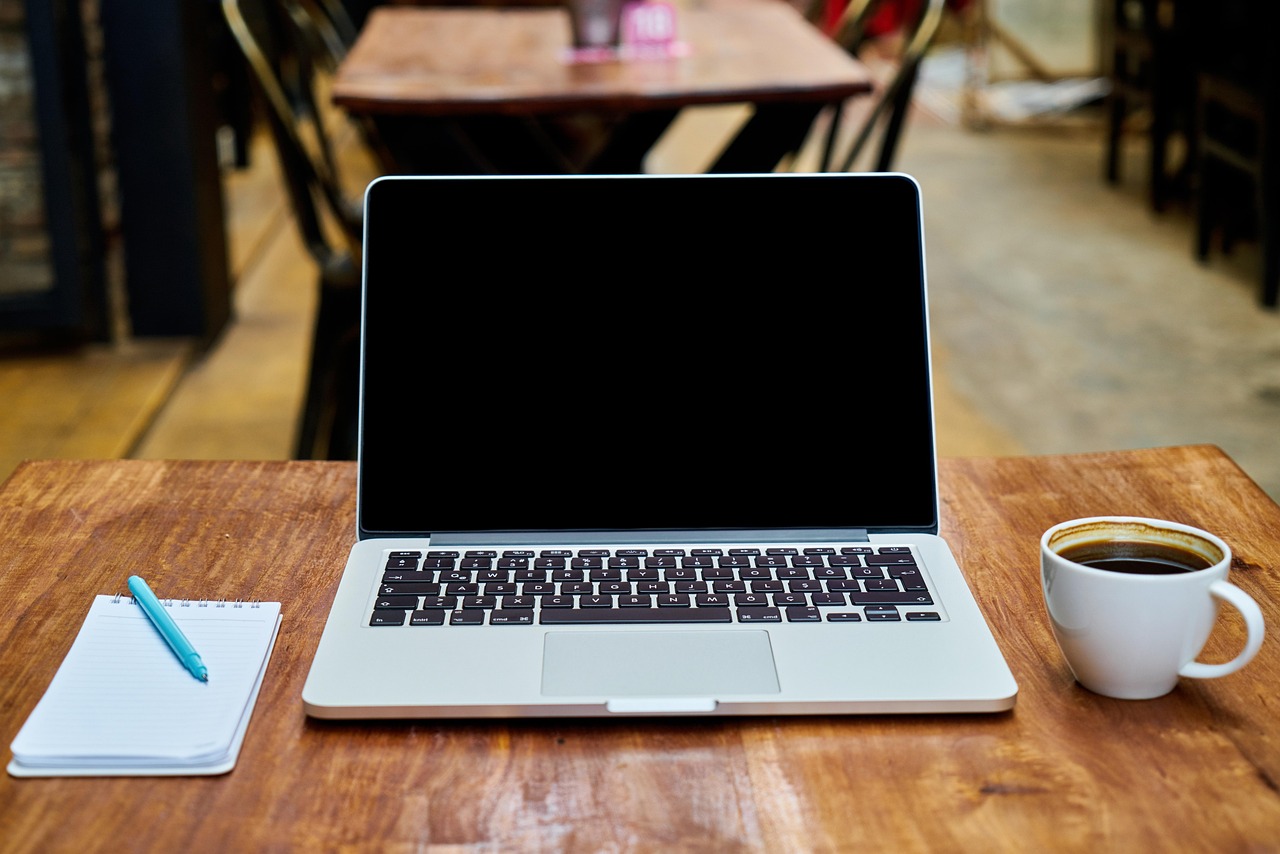 Persoon die werkt op een laptop in een café verbonden met openbaar wifi