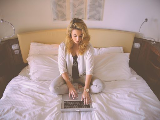 Persoon werkt aan laptop op een warme zomerdag met zonlicht door het raam
