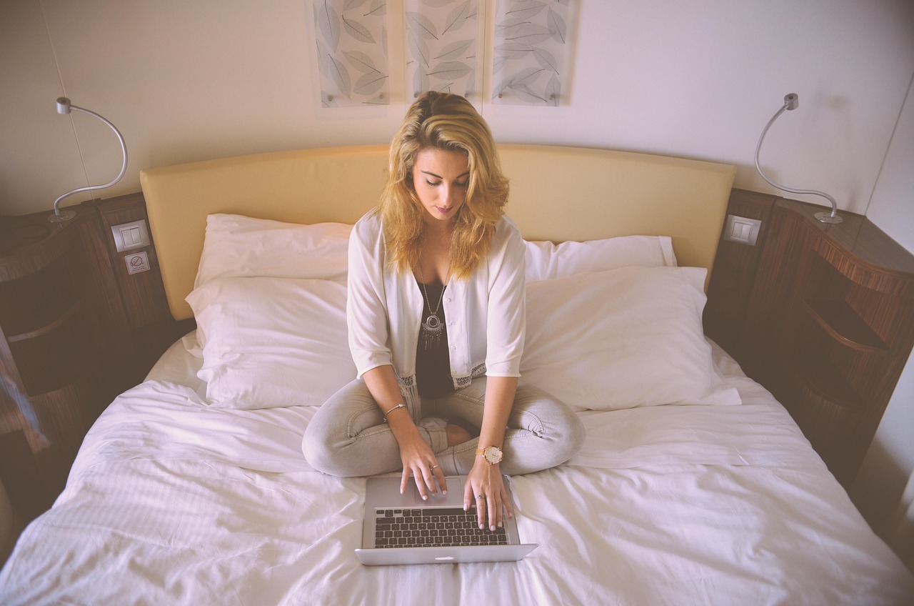 Persoon werkt aan laptop op een warme zomerdag met zonlicht door het raam