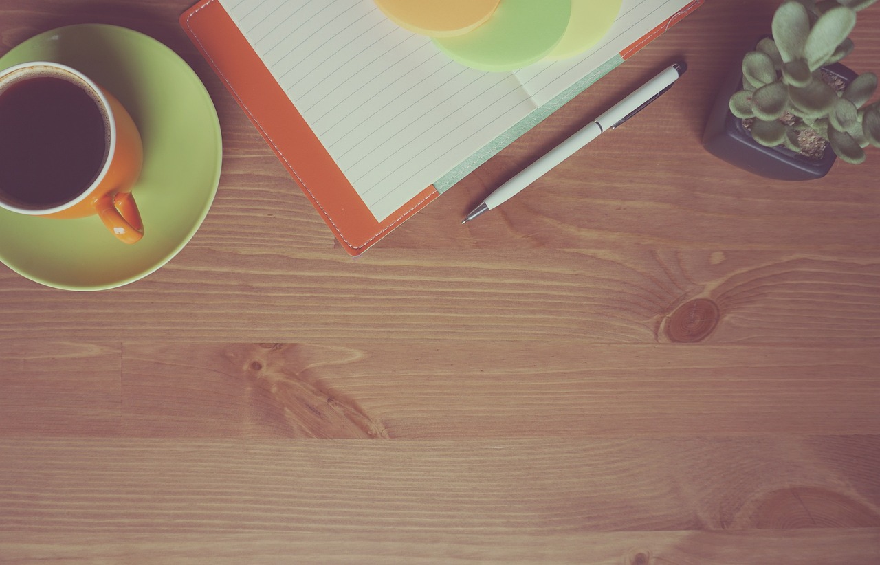 Freelancer die zijn maandelijkse inkomsten bijhoudt in een notitieboek aan een bureau