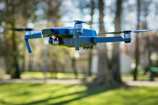 Een drone die vliegt boven een groen park op een zonnige dag