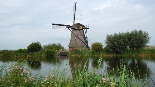 Nederlandse poldermolen weerspiegeld in het water, symbool voor eeuwenoude waterbeheerstechniek