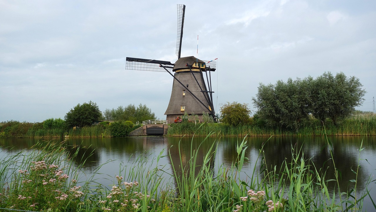 Nederlandse poldermolen weerspiegeld in het water, symbool voor eeuwenoude waterbeheerstechniek